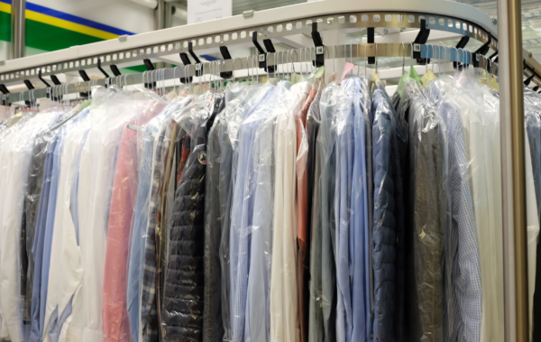 A photo showing different clothes on a dry cleaning rack.